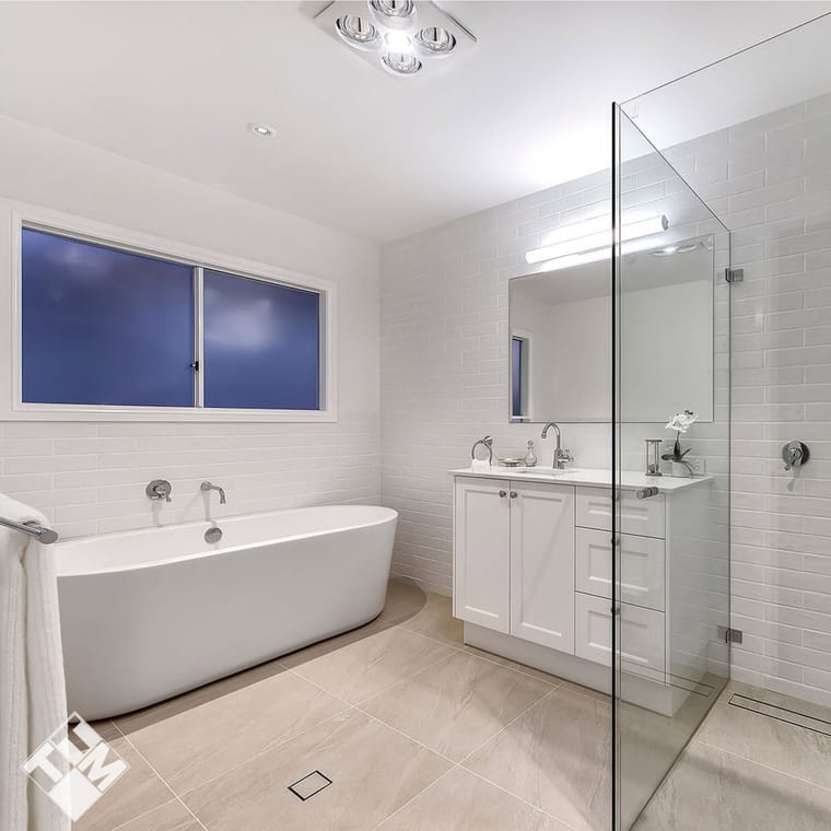 Freestanding bath, frameless shower and large-format wall tile