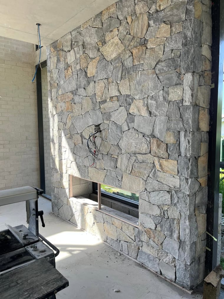 Dry-stack stone feature wall with recessed fireplace