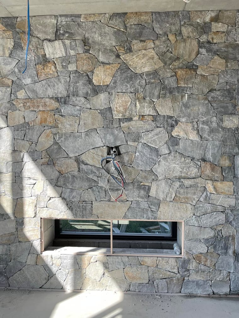 Exterior stone cladding around a picture window — tiling by Torrisi Tiling, Brisbane