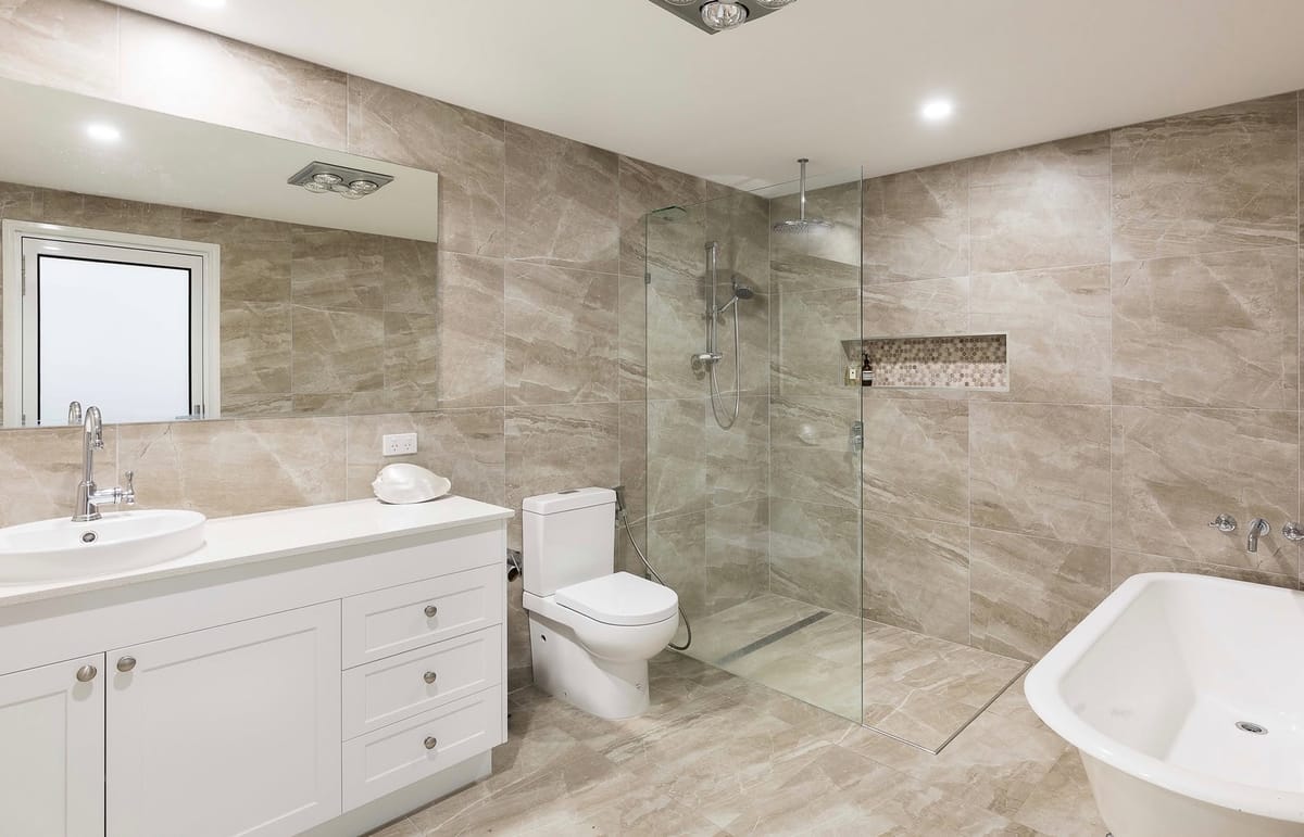 Stone-look ensuite with linear drain and frameless screen — tiling by Torrisi Tiling near Chermside, Brisbane