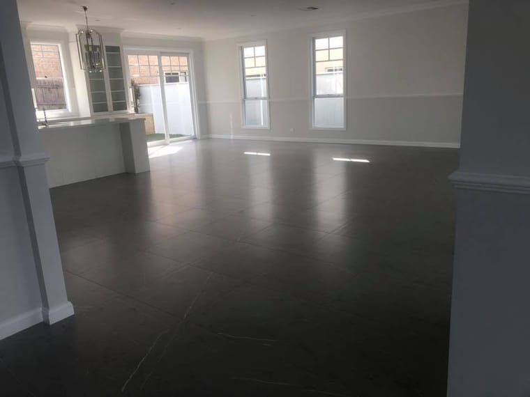 Dark large-format tile through open living — tiling by Torrisi Tiling, Brisbane