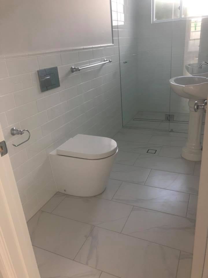 Marble-look floor with pedestal basin — tiling by Torrisi Tiling, Brisbane