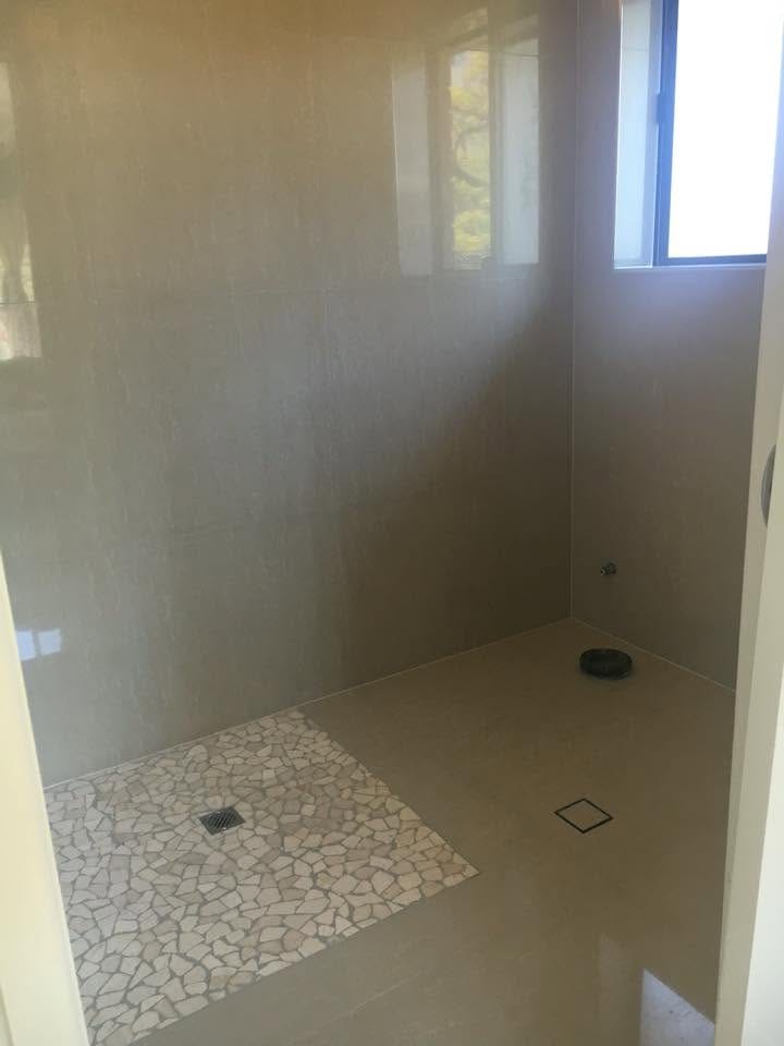 Walk-in shower with pebble base — tiling by Torrisi Tiling, Brisbane