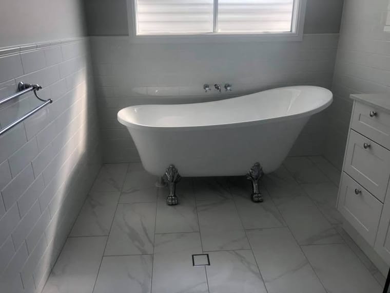 Freestanding bath on marble-look floor — tiling by Torrisi Tiling, Brisbane