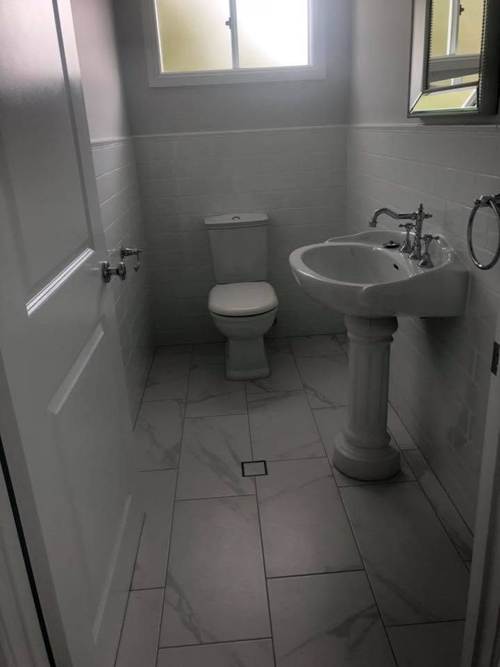 Marble-look bathroom with pedestal basin — tiling by Torrisi Tiling, Brisbane