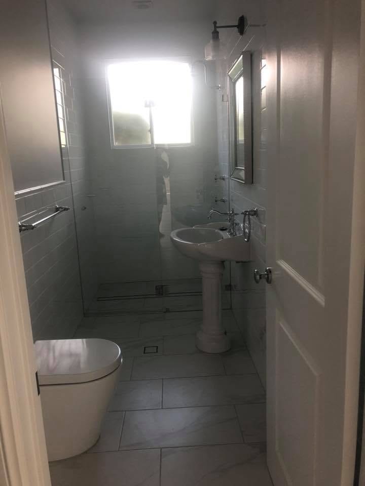 Freestanding bath, dark floor, natural light — tiling by Torrisi Tiling, Brisbane