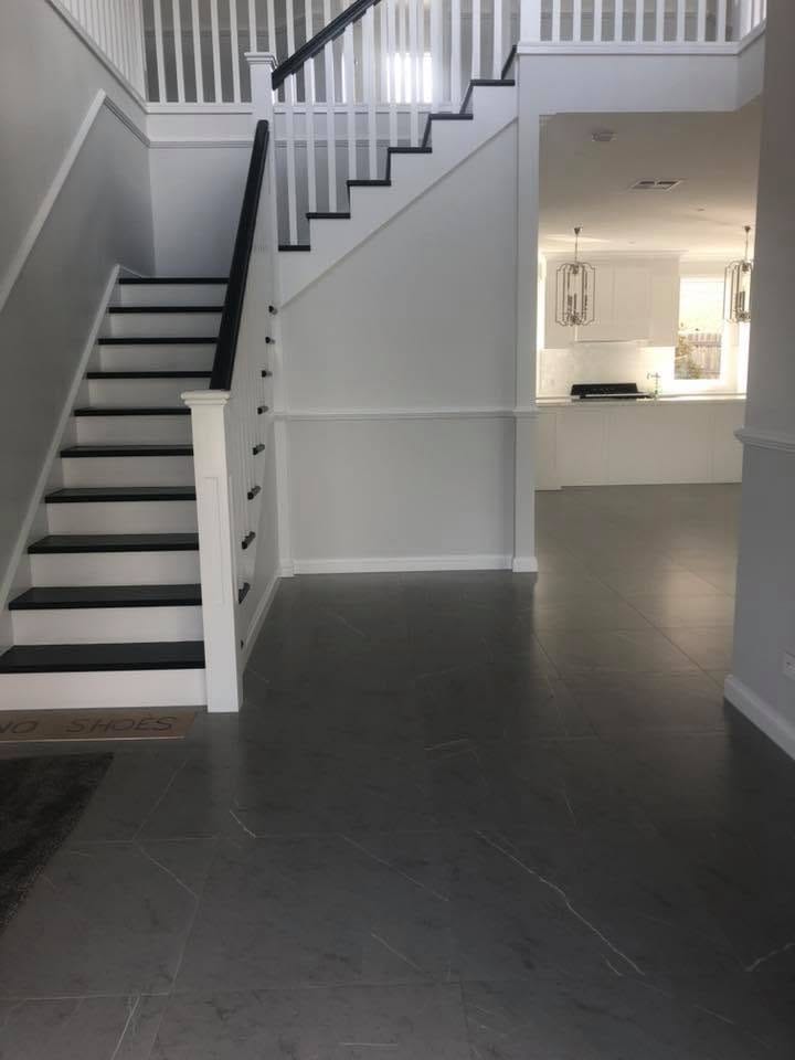 Staircase landing with dark floor tile — tiling by Torrisi Tiling, Brisbane