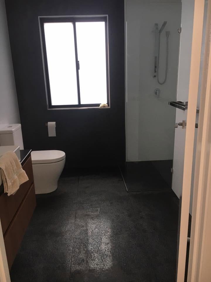 Bathroom with black door and dark floor — tiling by Torrisi Tiling, Brisbane