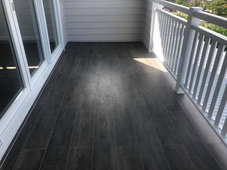 Verandah in dark timber-look tile — tiling by Torrisi Tiling, Brisbane