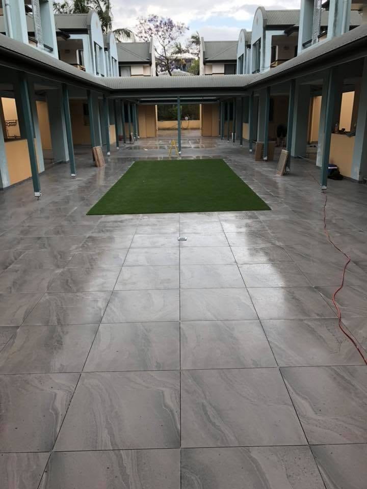 Courtyard paving with turf inset — tiling by Torrisi Tiling, Brisbane