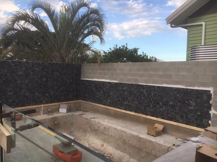 Pool shell and stone wall mid-build — tiling by Torrisi Tiling, Brisbane