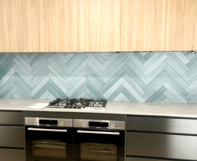 Herringbone glass splashback behind the cooktop